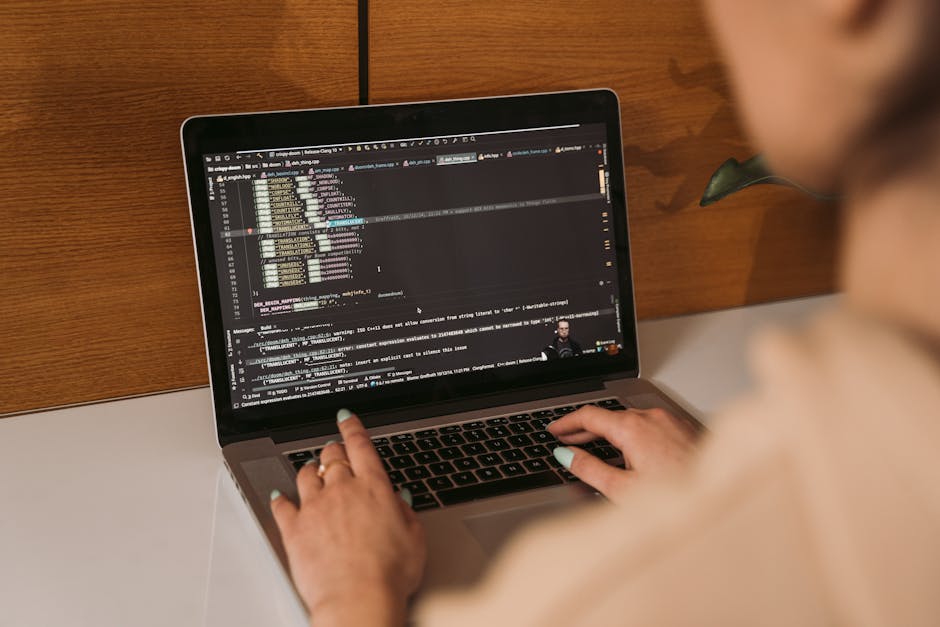 Laptop with code editor and project files on screen